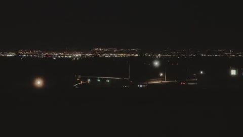 Cars Driving Through Night Intersection with Distant City Lights Stock Footage 341705866