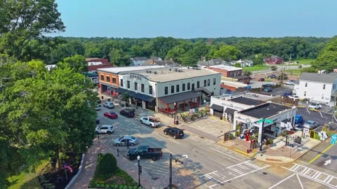 Cars fill busy intersection outside welcome center and shops in small town Vídeos de archivo 345100392