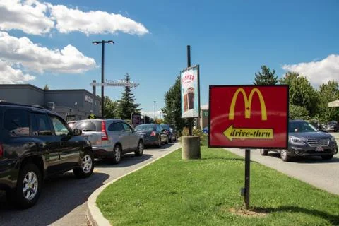 Cars lining up to order food using drive-thru facilities at local McDonald's Stock Photos