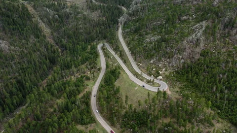 Cars navigate a switchback on a windy road in the Black Hills of SD 스톡 동영상 247363284