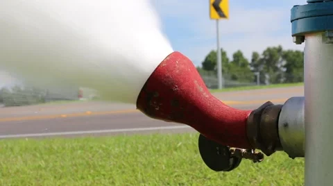 Cars Pass in Background of Fire Hydrant While Flushing Stock Footage 52888984