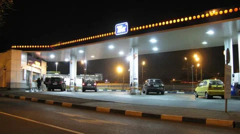 Cars pass in front of petrol station Stock Footage