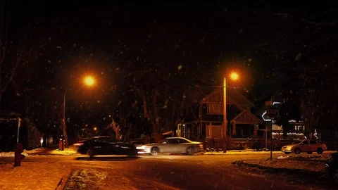 Cars Passing Houses At Night In Snowfall Stock Footage