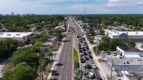 Cars queue along busy divided highway lined with strip malls in Clearwater Stock Footage 340042410