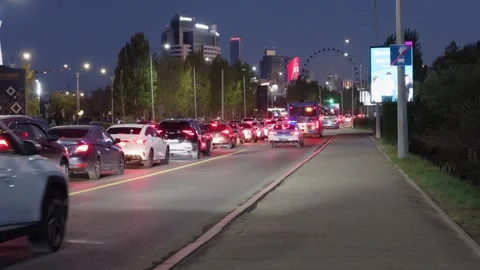 Cars queue in evening traffic with Ferris wheel Stock Footage 346572620