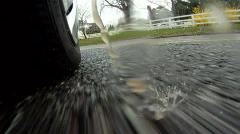 Car's tire hits a big puddle of rain (2) Stock Footage