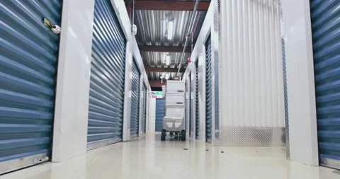 A cart full of boxes is pushed down a hallway Stock Footage 138665076