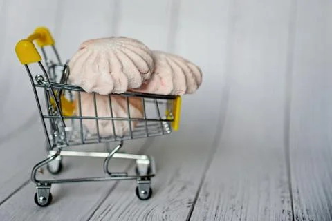 Cart with marshmallows on a light background. Creative idea for sale, promoti Stock Photos