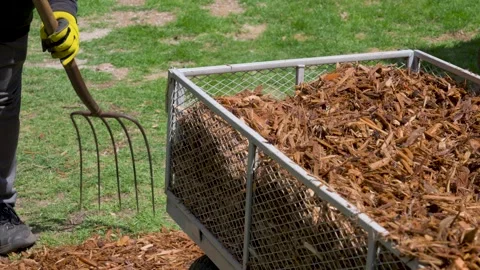 A cart of Mulch next to a man working a garden bed. Stock Footage 336466205