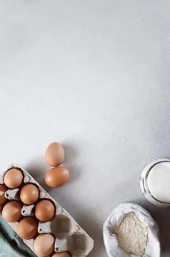 Carton of eggs, flour, sugar and kitchen textile napkin on concrete background 스톡 사진