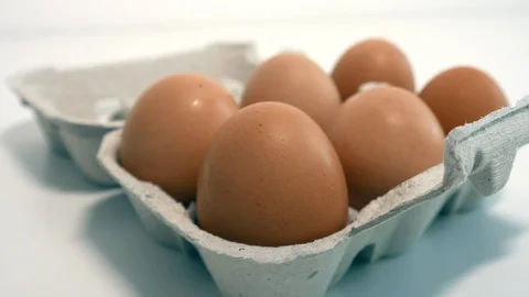 Carton of fresh eggs on the table, closeup slider shot left to right Stock Footage 108563521