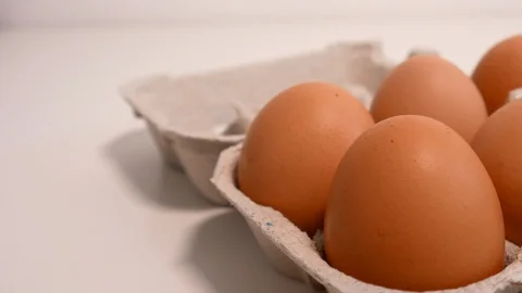 Carton of fresh eggs on white table, closeup slider shot Stock Footage 108563674