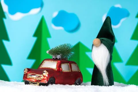 Cartoon composition of a small red car and a green Christmas gnome Stock-Fotos