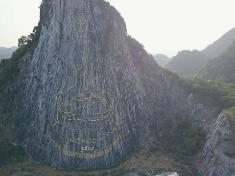 Carved buddha image from gold on the cliff at Khao Chee chan, Pattaya, Thailand Stock Footage 77325618