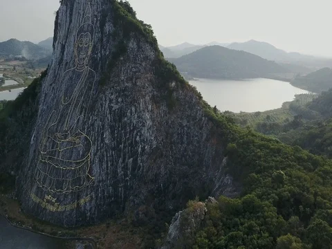 Carved buddha image from gold on the cliff at Khao Chee chan, Pattaya, Thailand Stock Footage 77325632