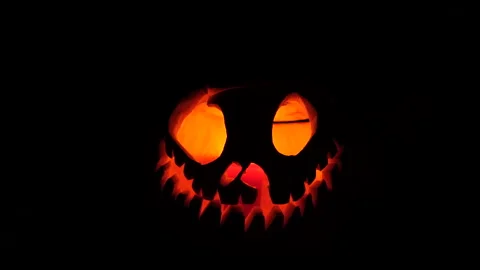 Carved Halloween Jack-o'-Lantern Glowing and Flickering in Complete Darkness Stock Footage 342563379