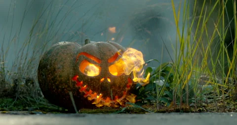 A carved pumpkin with fire comming out through eyes and mouth Video stock 145054513