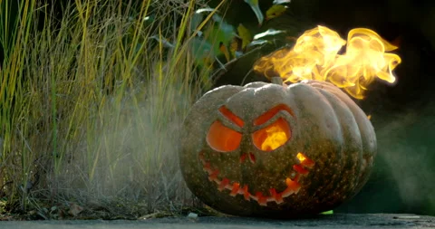 A carved pumpkin with fire comming out through eyes and mouth Stock-Footage 145054656