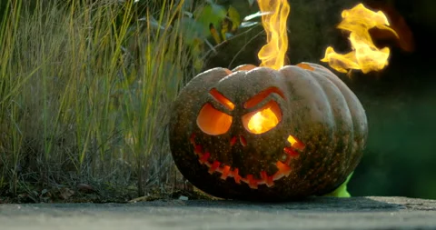 A carved pumpkin with fire comming out through eyes and mouth Stock Footage 145054676