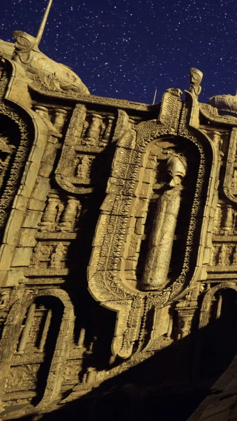 Carved stone wall with ancient figure at night under starry sky Video stock 331746912