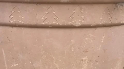 Carved tree patterns on a clay surface show traditional craftsmanship techn.. Stock Photos