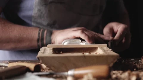 Carver processes the edges of an oak wood plank with a knife. artisan makes a Stock Footage 166082233