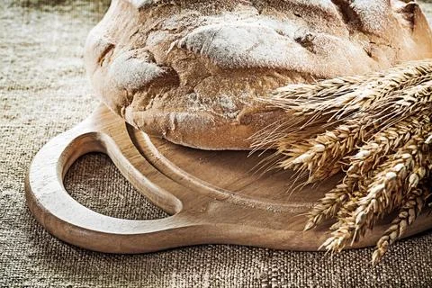 Carving board bread rye ears on vintage hessian background 写真素材