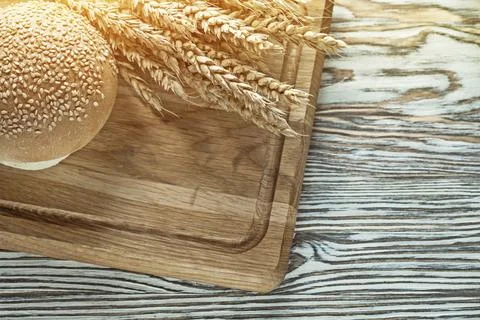 Carving board bread wheat ears on wooden surface 스톡 사진