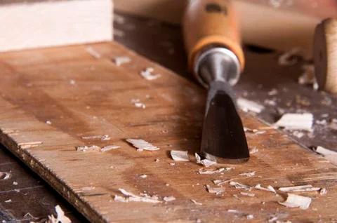 Carving chisel on workbench with scattered wood chips Fotos de archivo