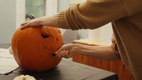 Carving the Face of the Jack-O'-Lantern into the Pumpkin 4K Stock Footage 308196899