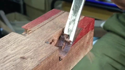 Carving grooves into a reddish wood with a chisel Stock Footage 317598766