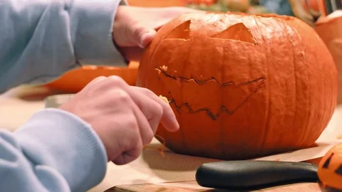 Carving Scary Jack O Lantern Face into Pumpkin Stock Footage 342281401