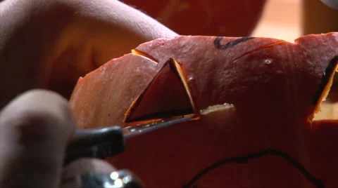 Carving the second eye on little halloween pumpkin face, closeup shot Stock Footage