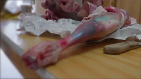 Carving, slicing preparing a joint of leg from goat .Greek easter celebration Stock Footage 222035504