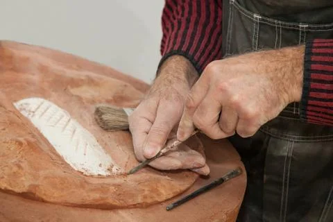 Carving the surface of baked clay using a chisel Stock Photos
