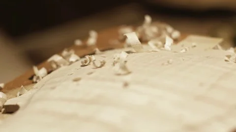 Carving a violin in a luthier workshop. Detail of wood dust Stock Footage