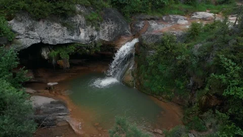 Cascada idilica rodeada de bosque verde en una vista aerea con drone 動画素材 134642053