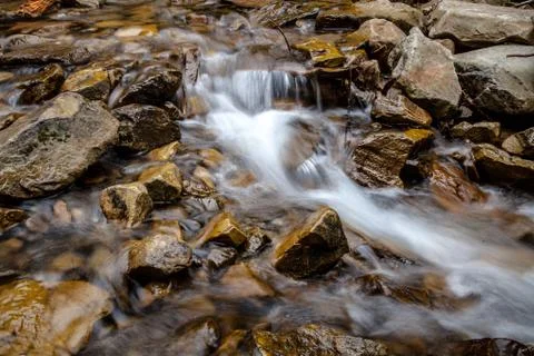 Cascade falls over mountain rocks Stock Photos
