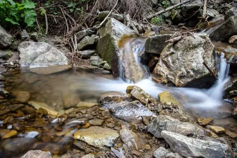 Cascade falls over mountain rocks Stock Photos