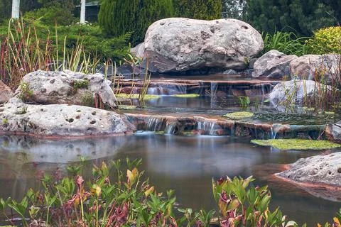 Cascade of shallow hand made small waterfall Stock Photos