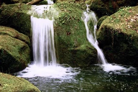 Cascade on small mountain stream. Cold crystal  water is falling over basal.. Stock Photos