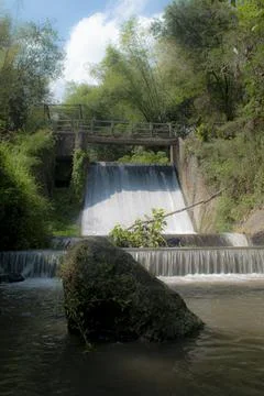 A cascade of water falling from a small dam  Stock Photos
