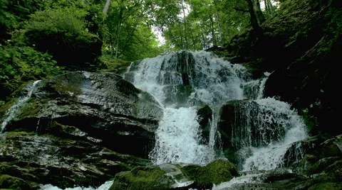 Cascade waterfall splash on stones in forest among mountains. Stock Footage 65490957