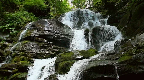 Cascade waterfall splash on stones in forest among mountains. Slow motion. Stock Footage 65529693
