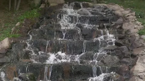 Cascade waterfall water rocks stone fresh nature garden countryside pan Stock Footage 332647107