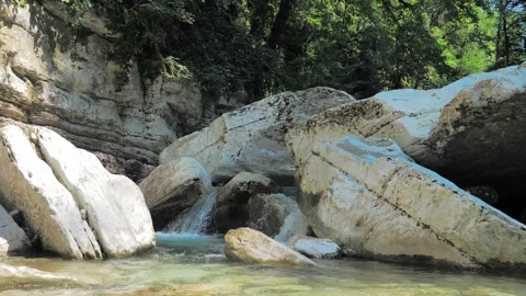 Cascades on small mountain stream. Water flows between big white stones in Stock-Footage 203858639