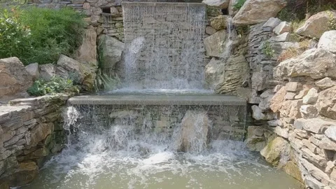 Cascading artificial waterfall made of stone Vídeo Stock 345303589