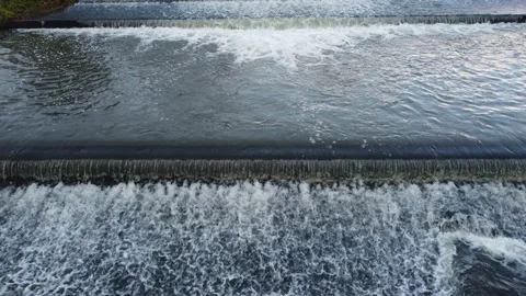Cascading bubbling river weir water flowing drone footage Stock Footage 166929517