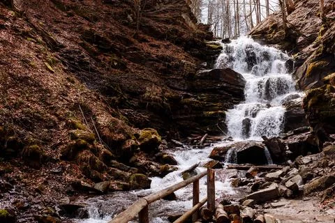 Cascading down a small mountain stream, the water runs over basalt boulders. A Stock Photos