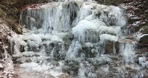 Cascading ice formations create a winter wonderland on a natural rock face Stock Footage 324866010